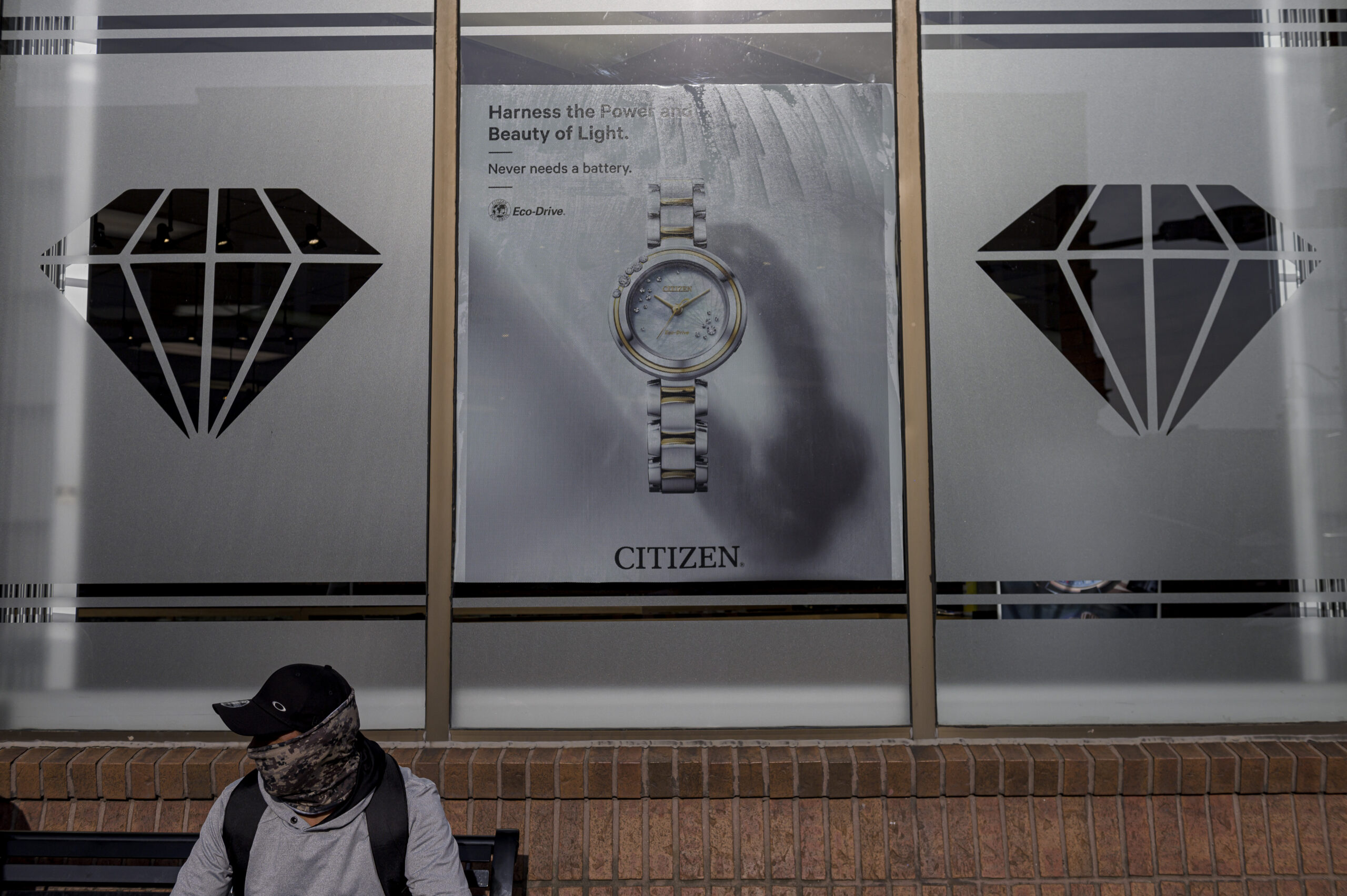 A photo of a migrant worker sitting outside a strip mall in Leamington. 