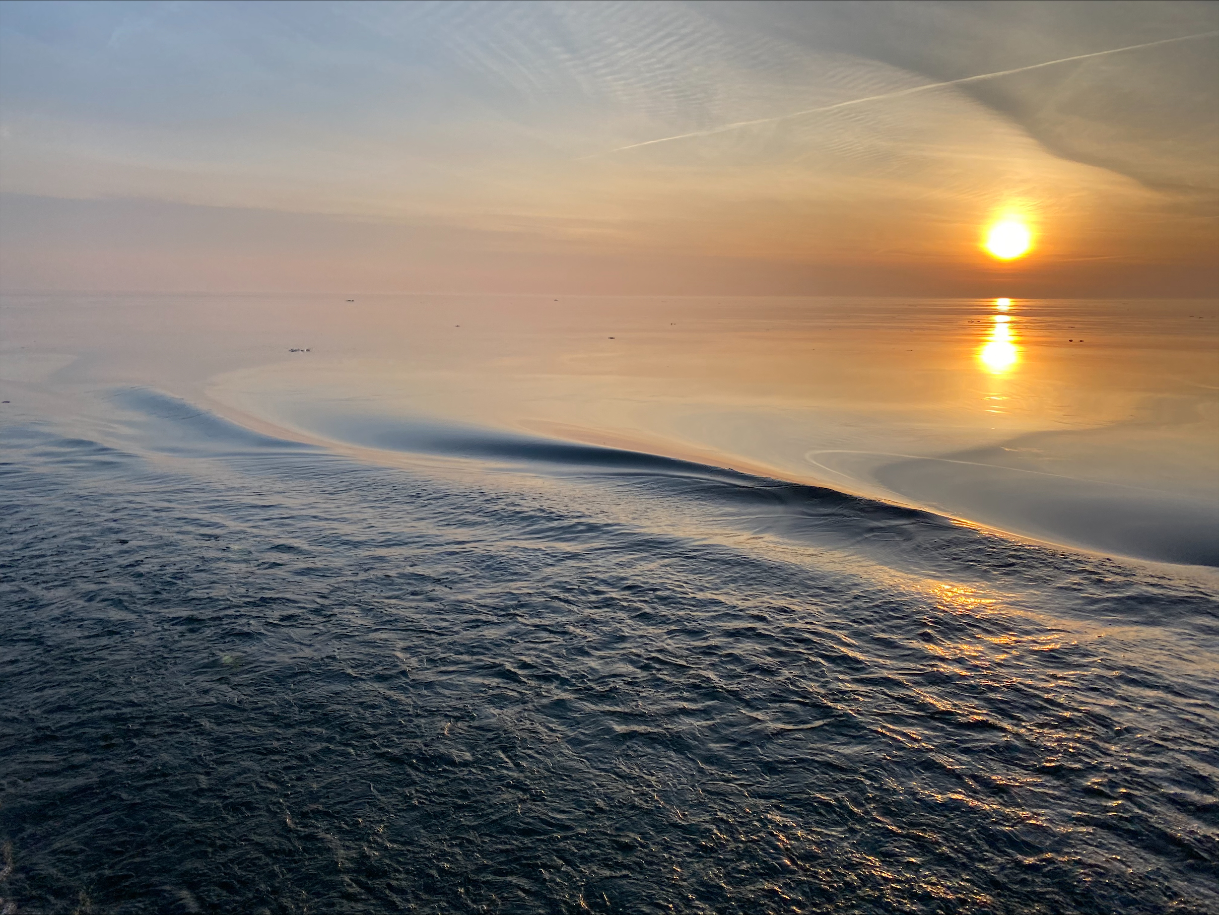 The yellow sun rises over the horizon on Lake Erie